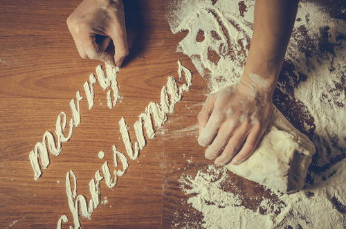 Dough being kneaded and flour saying Merry Christmas