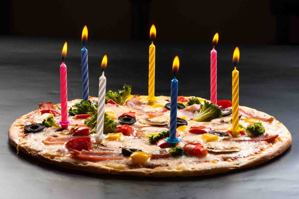 A pizza with birthday candles on it