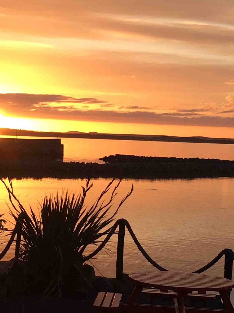 Sunset over Lochindaal from the outdoor dining area 'The Terrace' at Peatzeria restaurant on Islay