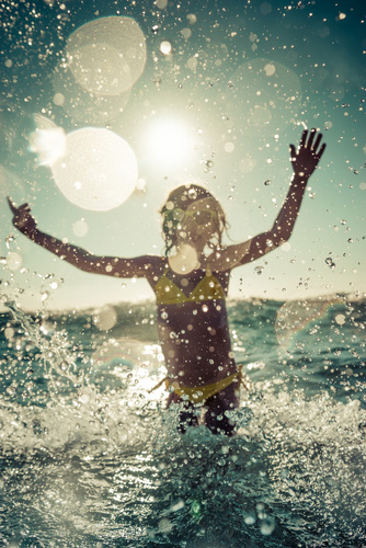 A young child splashing in the sea