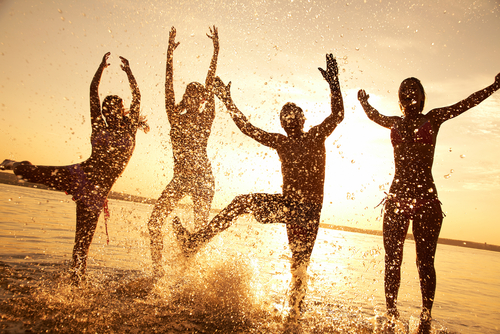 A group of people having a splash on a sunset beach
