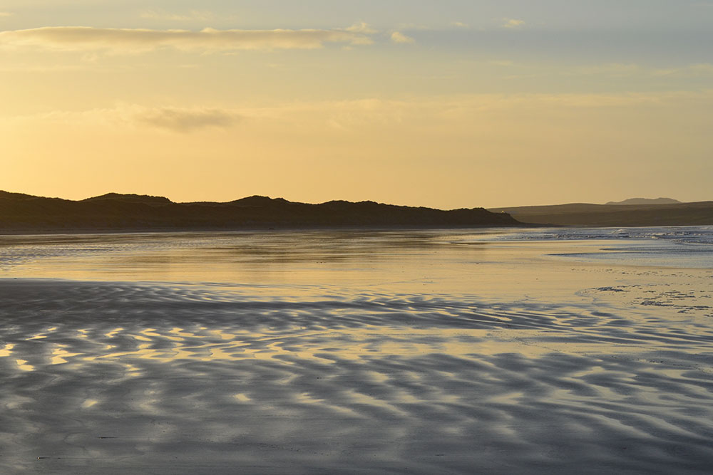 A sandy beach at sunset on Islay