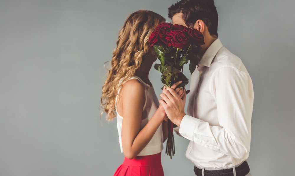 Couple kissing behind roses