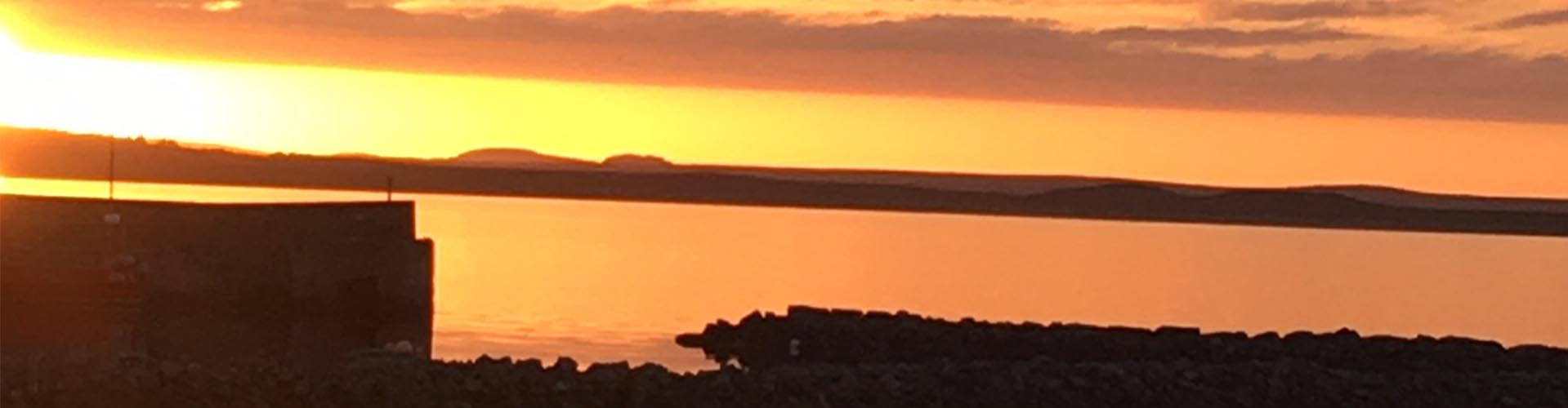 Lochindaal at sunset from the outdoor dining area at Peatzeria restaurant on Islay