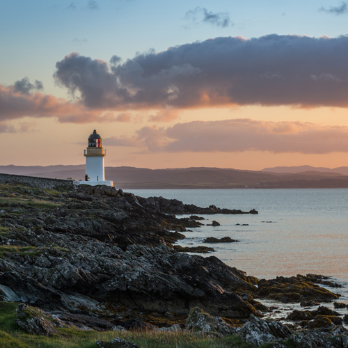 Coastal view at sunset with lighthouse