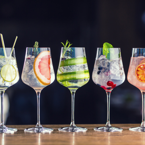 Row of gin cocktails on a bar top