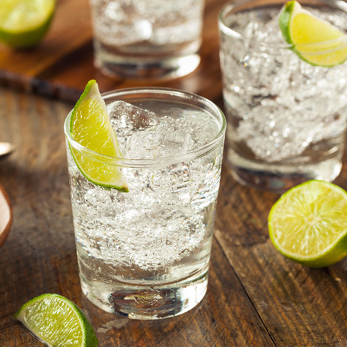 Glasses of gin and tonic with a lime garnish