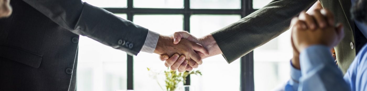 Business people shaking hands across a restaurant table