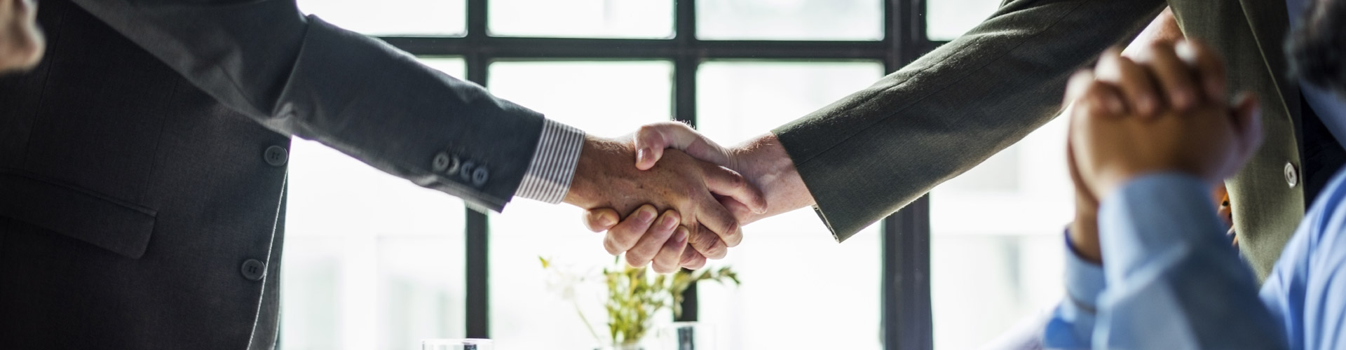 Business people shaking hands across a restaurant table