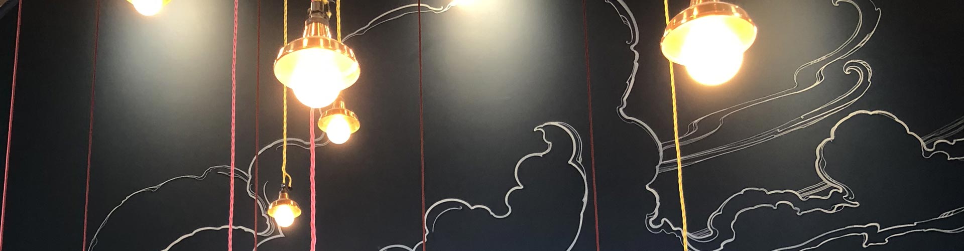 Cloud mural on restaurant wall with lights in front