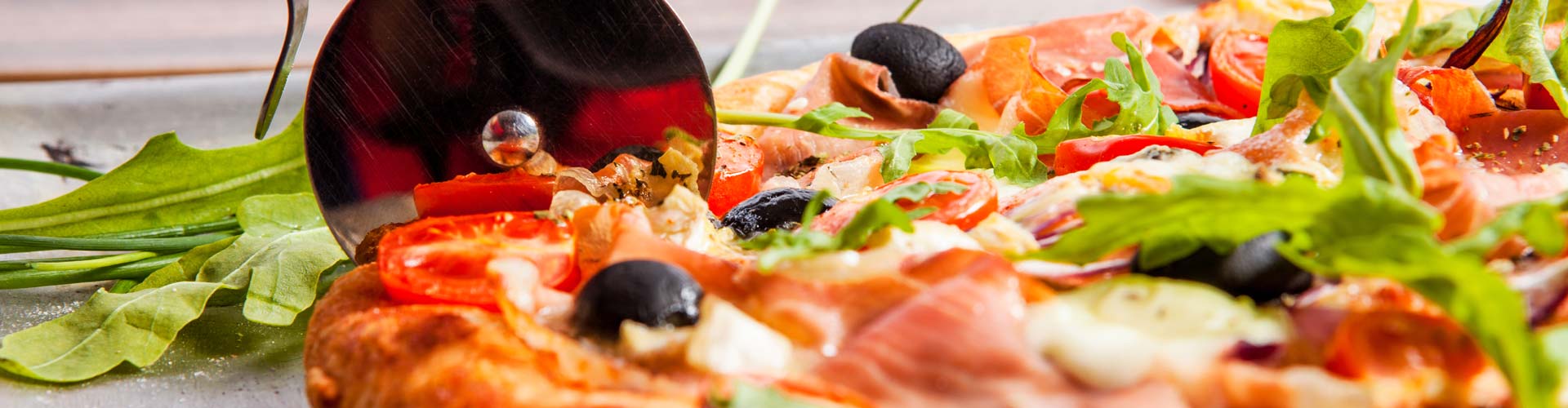 Pizza being sliced with a pizza cutter