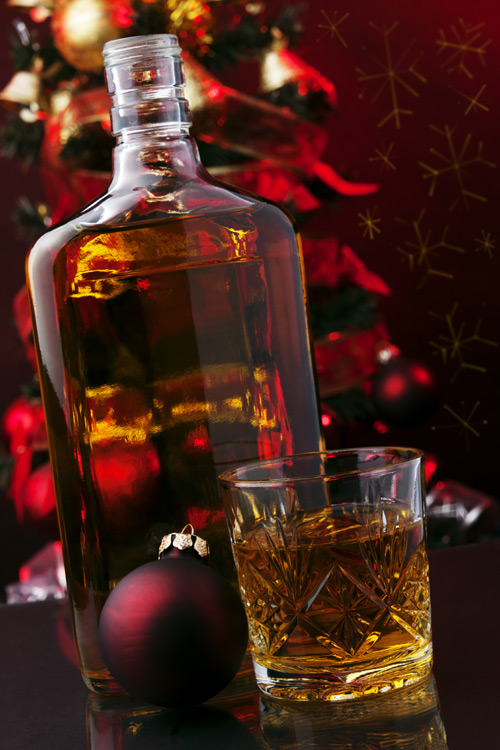 Whisky bottle and glass in front of Christmas lights
