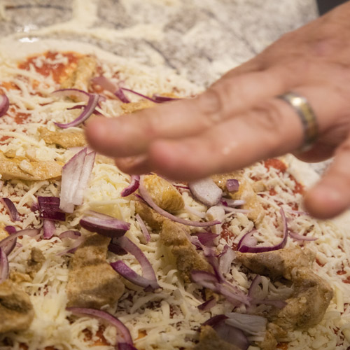 Adding toppings to a pizza before cooking