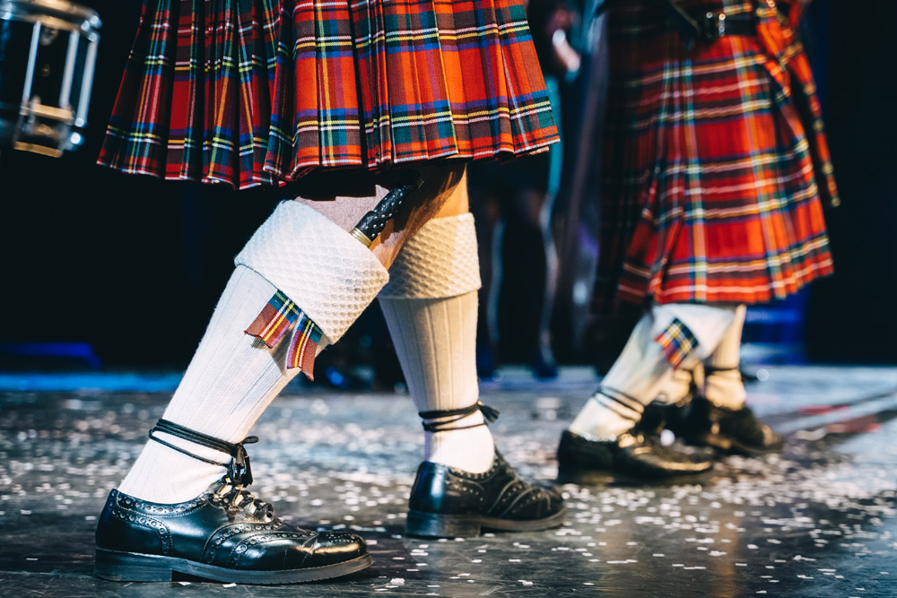 Scottish performers in kilts standing on stage