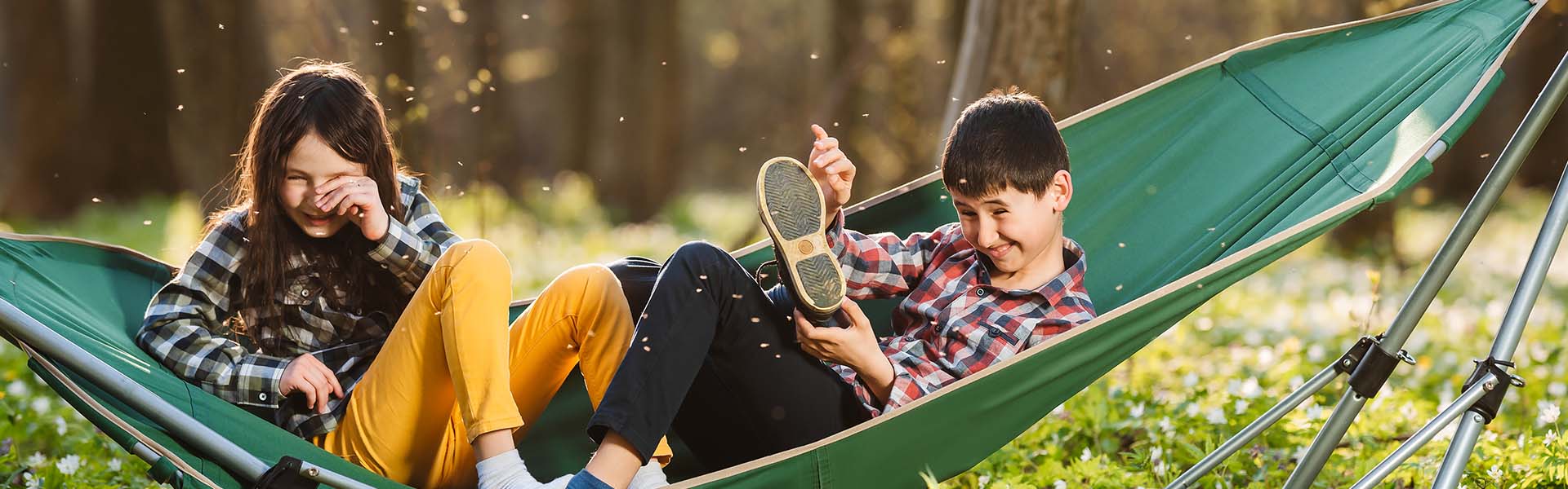 Two children on a hammock being bothered by Scottish midges