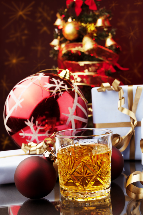 Christmas whisky in front of presents and baubles