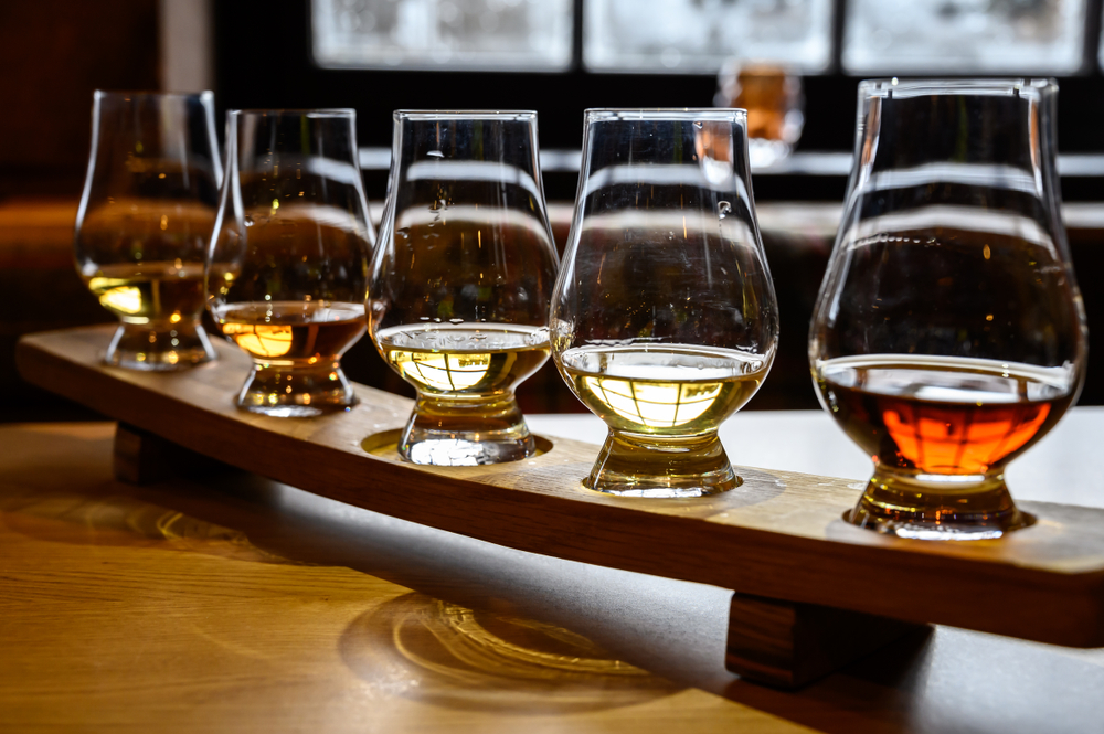 Set of Scottish whisky, tasting glasses with variety of single malts or blended whiskey spirits on distillery tour in Scotland.