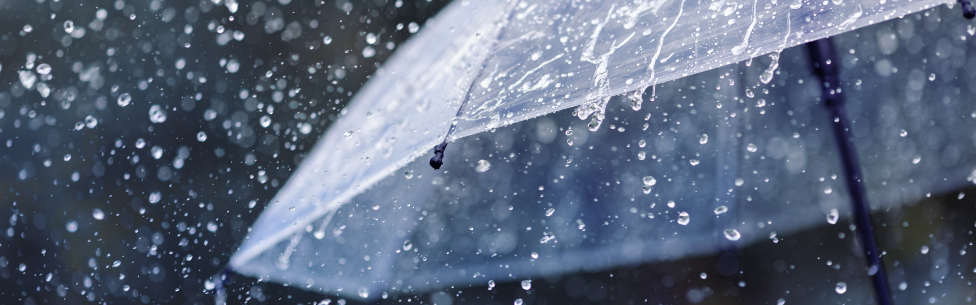 Rain bouncing off transparent umbrella