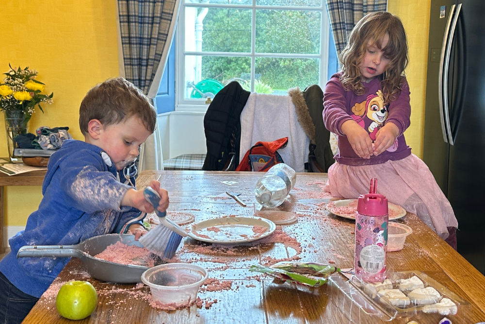 Children playing with moon sand at Islay cottages table 