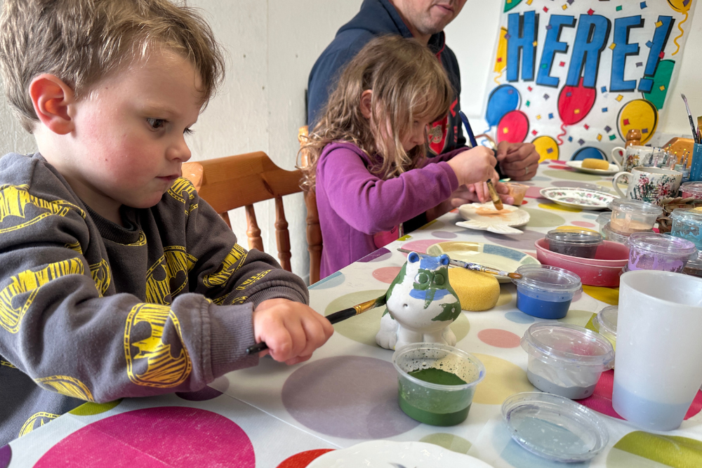 Two children painting pottery