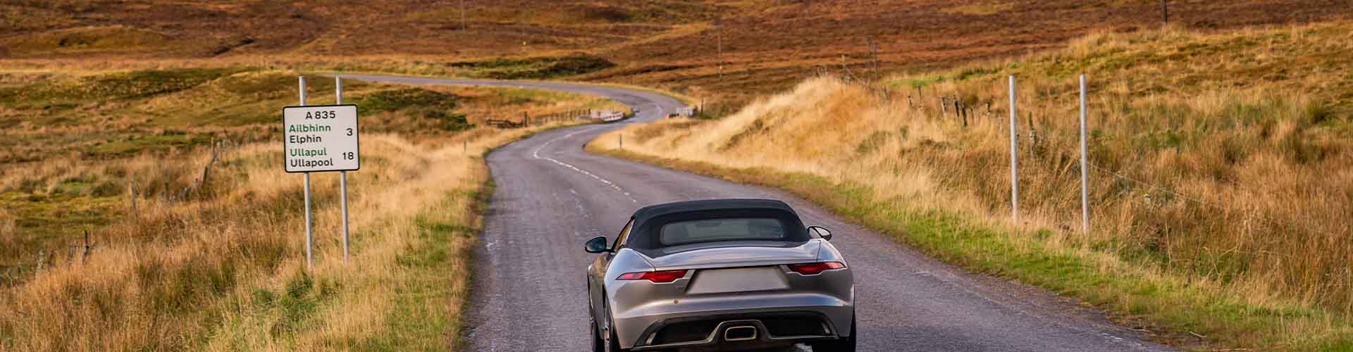 A car on a highland road in Scotland.