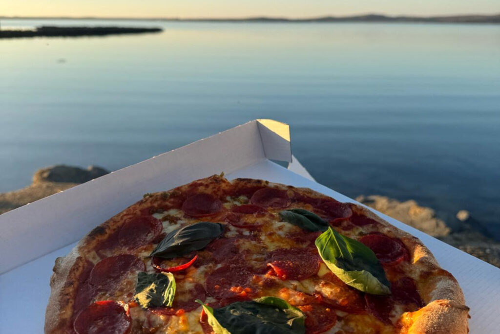 Pizza in a takeaway box with Scottish scenery
