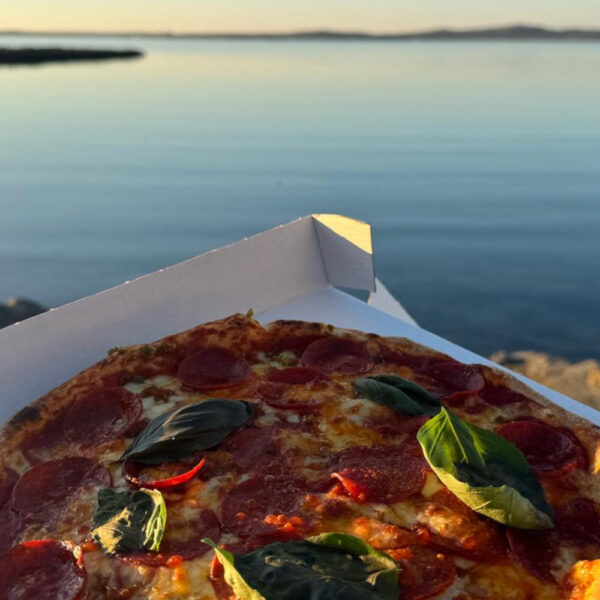 Pizza in a takeaway box with Scottish scenery